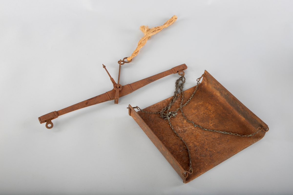 Skålvekt i metall. 
Mangler loddene for vekta, som skal stå på brettet. 
Skåla, hvor det som skulle veies ble plassert er dråpeformet. Antatt fordi det som skulle veies enklere kunne helles ut. 
Noe rust.
Består av to deler. Skålvekt og oppheng