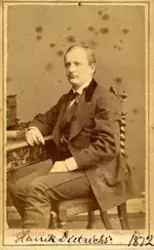 Studioportrett av mann sittende på stol.