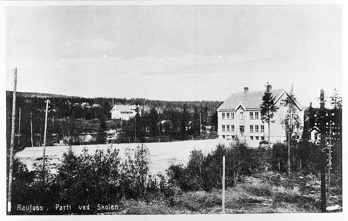 Postkort med motiv fra Raufoss. Bildet er tatt fra torvet, og viser Brubakken skole. Huset i midten er "Direktørboligen".