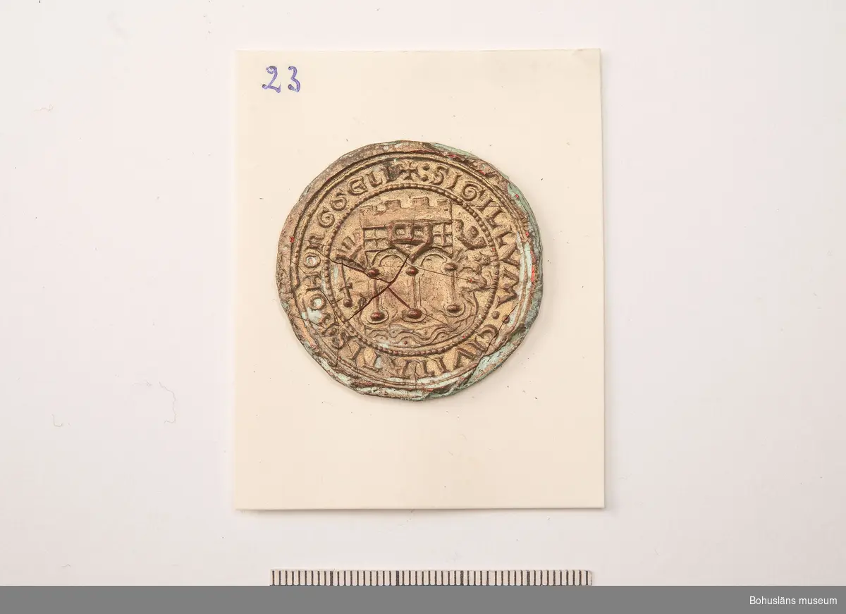 Ur handskrivna katalogen 1957-1958:
Sigillavtryck
Diam.: c:a 4. Kungahällas äldsta sigill. Helt, men med små sprickor.

Ur Knut Adrian Anderssons katalog:
4. Avtryck av det gamla Kongahellas 
äldsta sigill, antagligen från 11-1200-
talet. Sk. 1869 av G. Brusewitz.