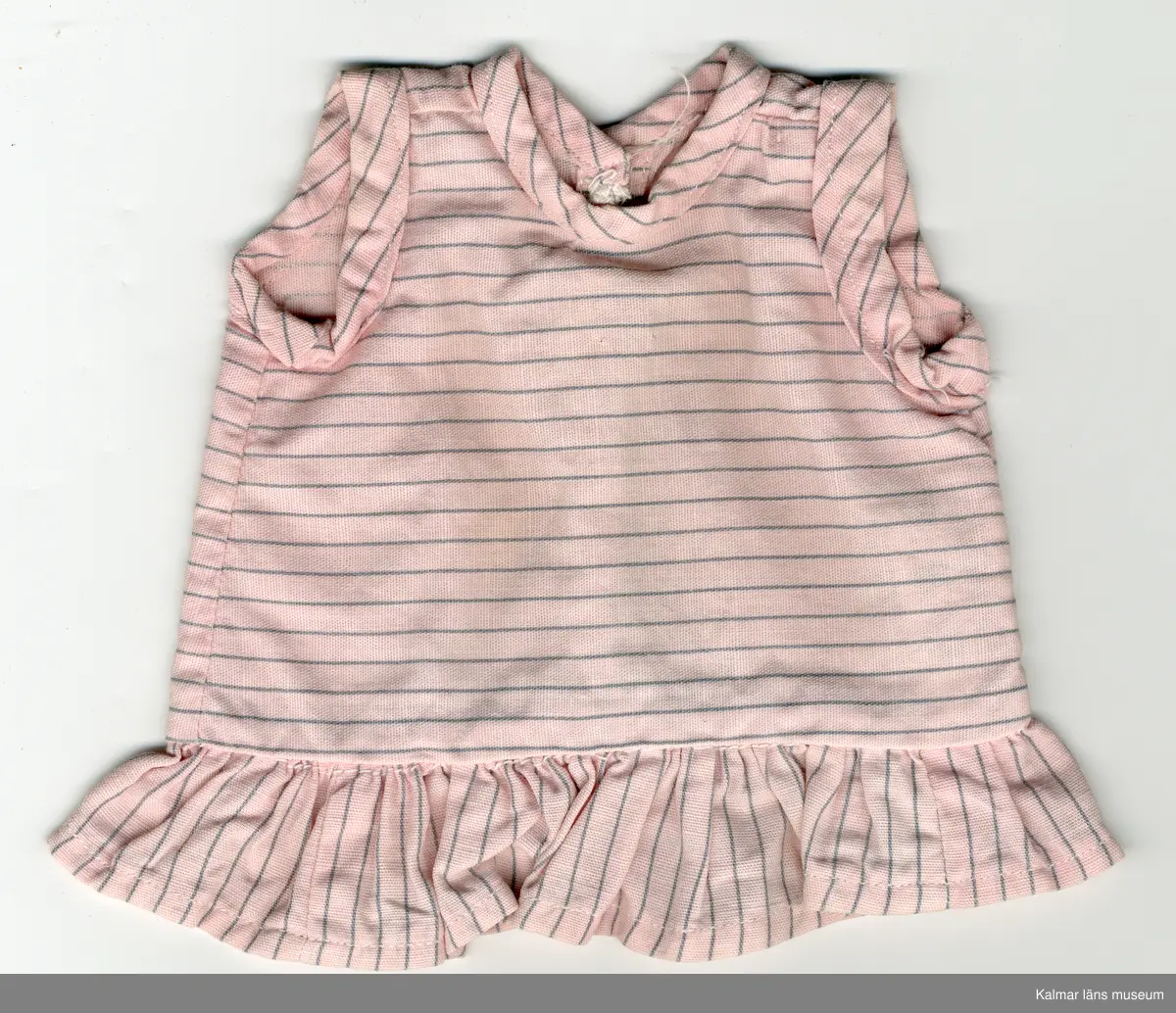 KLM 45519:16:9. Dockklänning, av textil, bomull och metall, rosa botten med ränder, smala, gråa. Överdel, tygets randning vågrät, ärmhål och halslinning kantade med klänningstyg sytt som kantband. Knäppes baktill med tre tryckknappar. Kjol, kort, rynkad, tygets randning, lodrät. Klänningen har fläckar av grå färg.