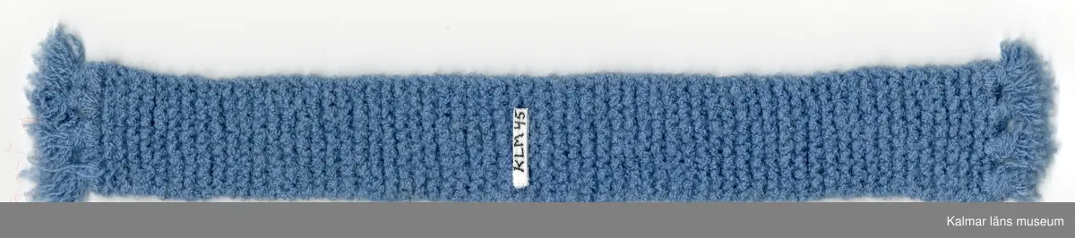 KLM 45519:16:8. Dockhalsduk, långhalsduk, blå, av konstmaterial, handstickad, med frans.