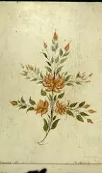 Detaljbild på skåpdörr. Blomstermåleri.