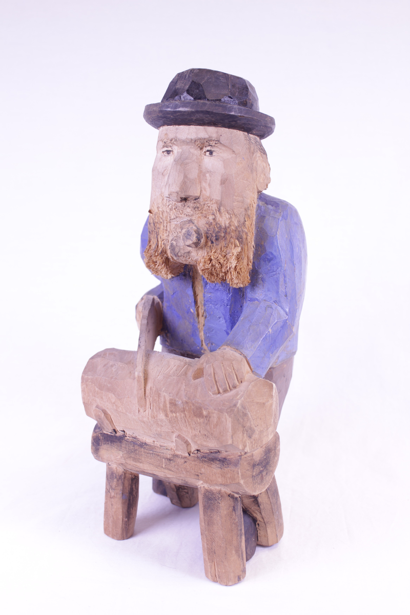 Mann som sager en stokk. Malt.