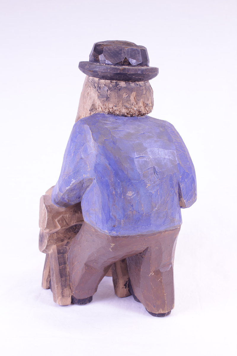 Mann som sager en stokk. Malt.