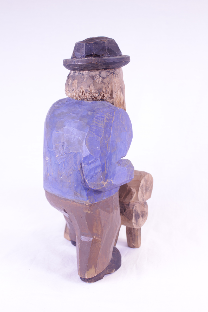 Mann som sager en stokk. Malt.