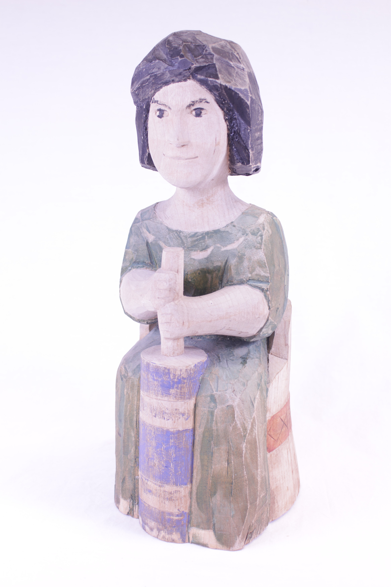 Kvinne på kubbestol som kinner smør.