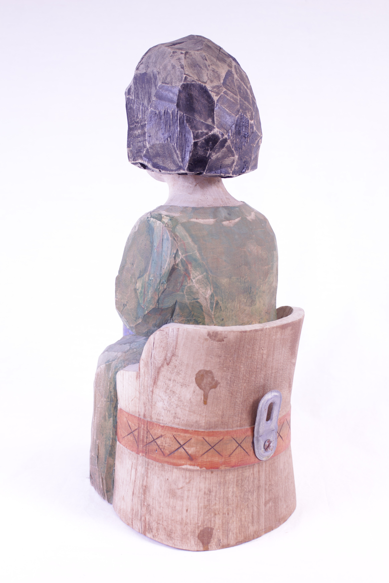 Kvinne på kubbestol som kinner smør.