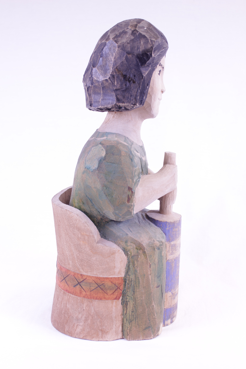 Kvinne på kubbestol som kinner smør.