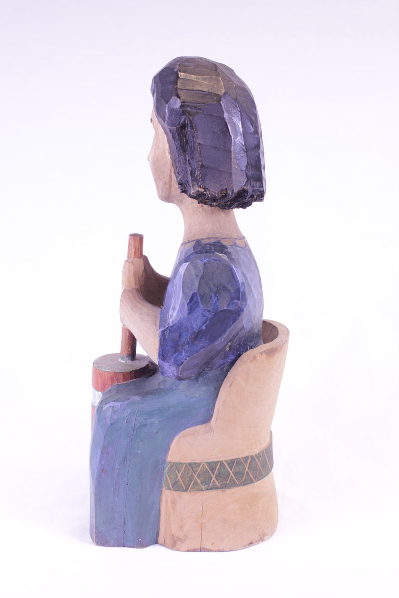 Kvinne på kubbestol som kinner smør.