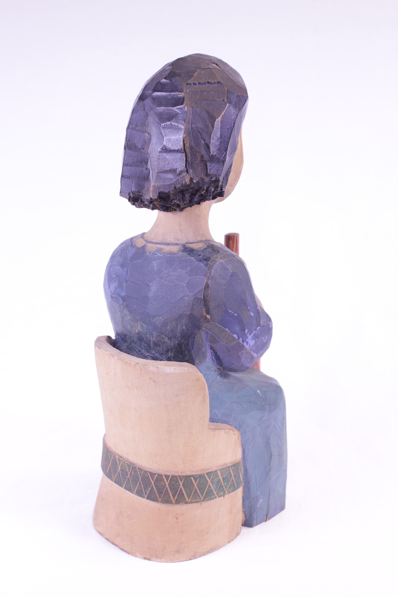 Kvinne på kubbestol som kinner smør.