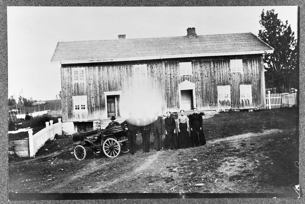 Bygningen på øvre Heggenes sett fra vest rundt år 1900.
Bak kalesjevogna står Hans Chritian Heggenes (Lier). De neste tre er utydelige, men to av dem er Mathias og Einar Heggenes, så Augusta Blilie og Oleane Heggenes.