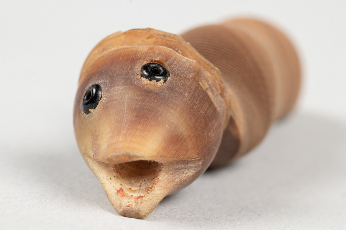 Deler til leketøy formet som fisk. Tre utskårede fiskehoder, samt kropp til fiskene i papir formet som en spiral som kan trekkes ut som et trekkspill