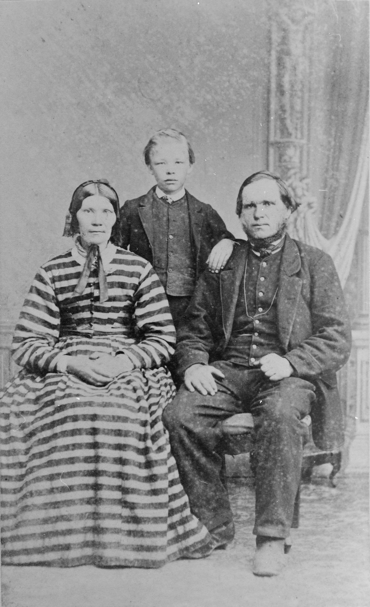 Kornelius Bendiksby (f. 1820) med hustru Marthe Kristoffersdatter Bendiksby (f. 1820) og sønnen Kristoffer Bye. Atelierfoto, rundt 1870.