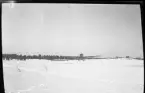 Flygplan kommer inför landing på snötäck åker.