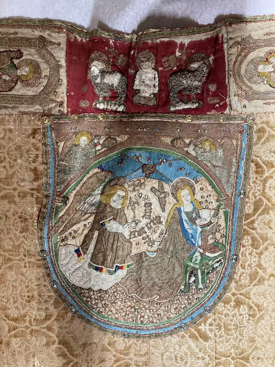 Korkåpa av skuren brungul sammet (ursprungligen röd) med granatäpplemönster och broderier. Kåpan är daterad till Sturegotiken och är troligen ett Vadstena-arbete.

Längs kåpans ytterkant ett band i rött, blått och guld, kantat av silkesfrans randad i flera partier i ursprungligen rött och grönt - nu gulgrått. Utmed framkanterna linnebårder med figurer i aediculor, guld, silver och mångfärgat silke. Å högra sidan jungfru Maria, Petrus, Johannes Döparen, helgon med stav och helgon med kors. Å vänstra sidan okända helgon, Sankt Paulus, Sankt Andreas och okänd apostel med spjut. Figurerna inom rundbågar av guld, på marken strödda blommor.

Vid nacken på rött ylle (ursprungligen täckt av rött taftliknande siden) syns Kristus som smärtoman i halvfigur omgiven av två Guds lamm, på dipens Marie bebådelse med inskrift "AVE MARIA GRA". På broderierna strödda metallpajletter.

Tyget är troligen vävt i Italien under 1400-talets andra hälft. Kåpans montering med band och silverfrans är ursprunglig och kan dateras till 1400-talets senare del eller omkring 1500. Broderierna är troligen utförda i Tyskland under 1400-talets andra hälft. Brämets broderi delvis ibroderat, troligen under 1600- eller 1700-talen.