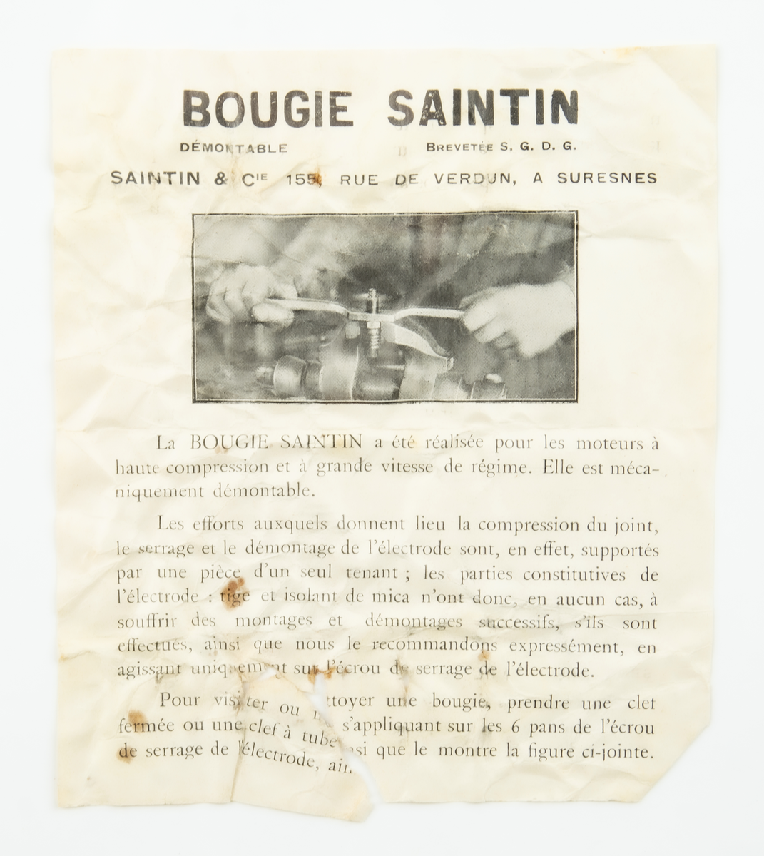 Tändstift, av fabriketet Saintin. Förvaras i originalförpackning i form av ett blått papprör med etikett med bland annat texten Bougies Saintin och dateringen 1927. I förpackningen följer en dokument. (Tändstift för motorer med hög kompression och hög hastighet.)