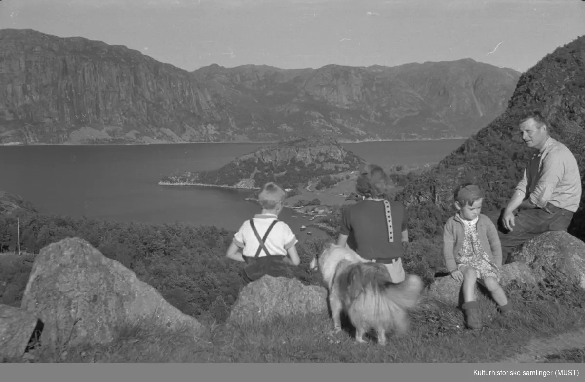 Utsikt over fjorden. Ei familie med en hund.