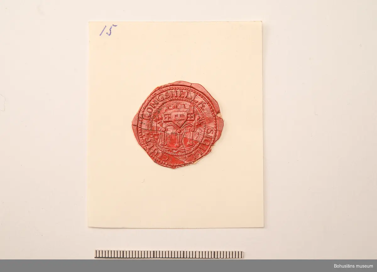 Ur handskrivna katalogen 1957-1958:
Sigillavtryck
Diam.: c:a 4. Kungahällas äldsta sigill. Helt, men med små sprickor.

Ur Knut Adrian Anderssons katalog:
4. Avtryck av det gamla Kongahellas 
äldsta sigill, antagligen från 11-1200-
talet. Sk. 1869 av G. Brusewitz.