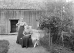 Systrarna Helga och Hilma Nilsson framför barndomshemmet Eketorp i Vist socken. De hade blivit moderslösa redan som barn. Yngsta systern bar knappast ens minnen av sin mor. Nu till den förmodade sommaren 1909 hade de även blivit faderslösa och torparkontraktet skulle gå till ny brukare. Förändringens tid var således kommen. För Hilmas del var framtiden utstakad. Hon var förlovad och till hösten kom hon att gifta sig med en fabriksarbetare och flytta till Skorpa trämassefabrik. Helga blev hushållerska i Kringstorp.