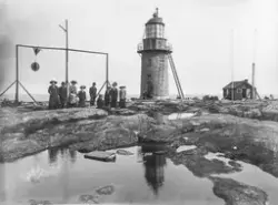 Gruppbild invid den gamla fyren på Brämön. Människorna är fi