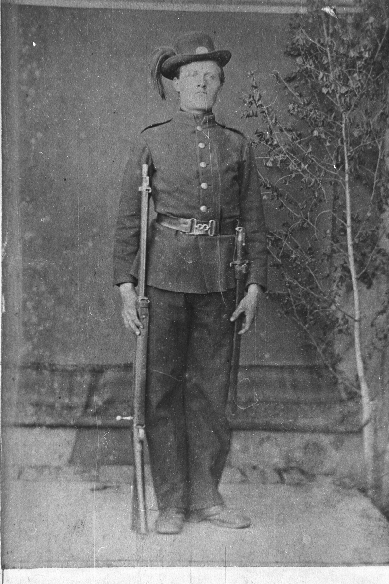 Portrett av Ola H. Hulebaklien i militær uniform og våben.