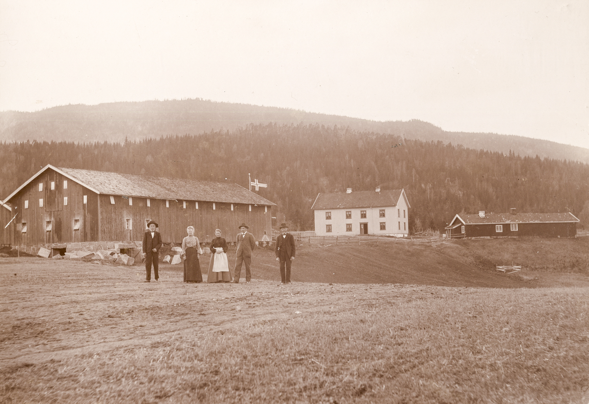 Øvre-Eid (Gamle-Eid), Eidsvenna Hvittingfoss før 1910.
Personer fra høyre Johannes Eid, Ole Eid f. 1874, d.1959, Katrine Eid f. Foss 1875, d.1927, 2 tjenestefolk.

Ole Eid bygde nye hus nede på sletta 1919-1910 og flyttet gården da det kom ny vei nærmere Lågen.
Materiale fra den gamle låven ble brukt i den nye.
Tora Teien kjøpte framhuset og drev privat gamlehjem en del år.
Huset ble senere solgt til Chr. Grønvold som lagde 6 leiligheter.
Huset brant ned til grunnen 5. juli 1951. 
Informant: Olaug Homb f. Eid 1905