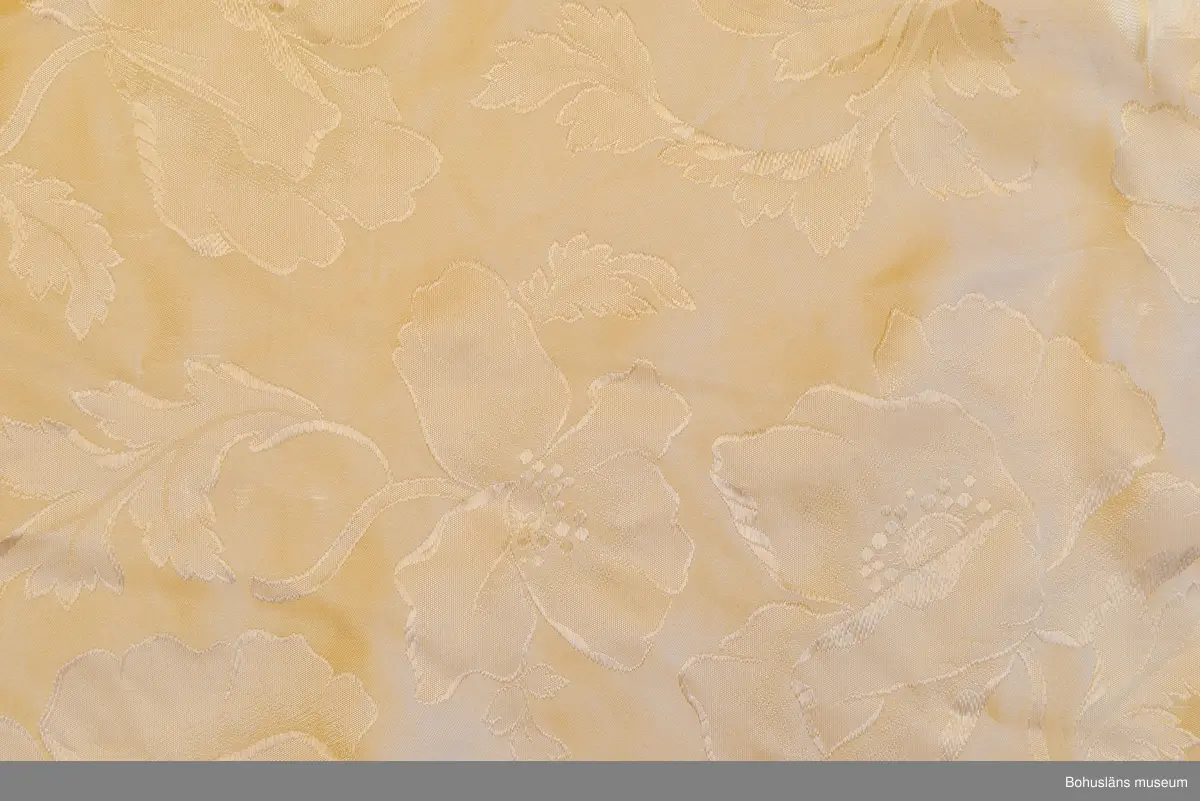 Kappa i svart sammet med vitt sidenfoder. Pellerinkrage och löst sittande skärp.