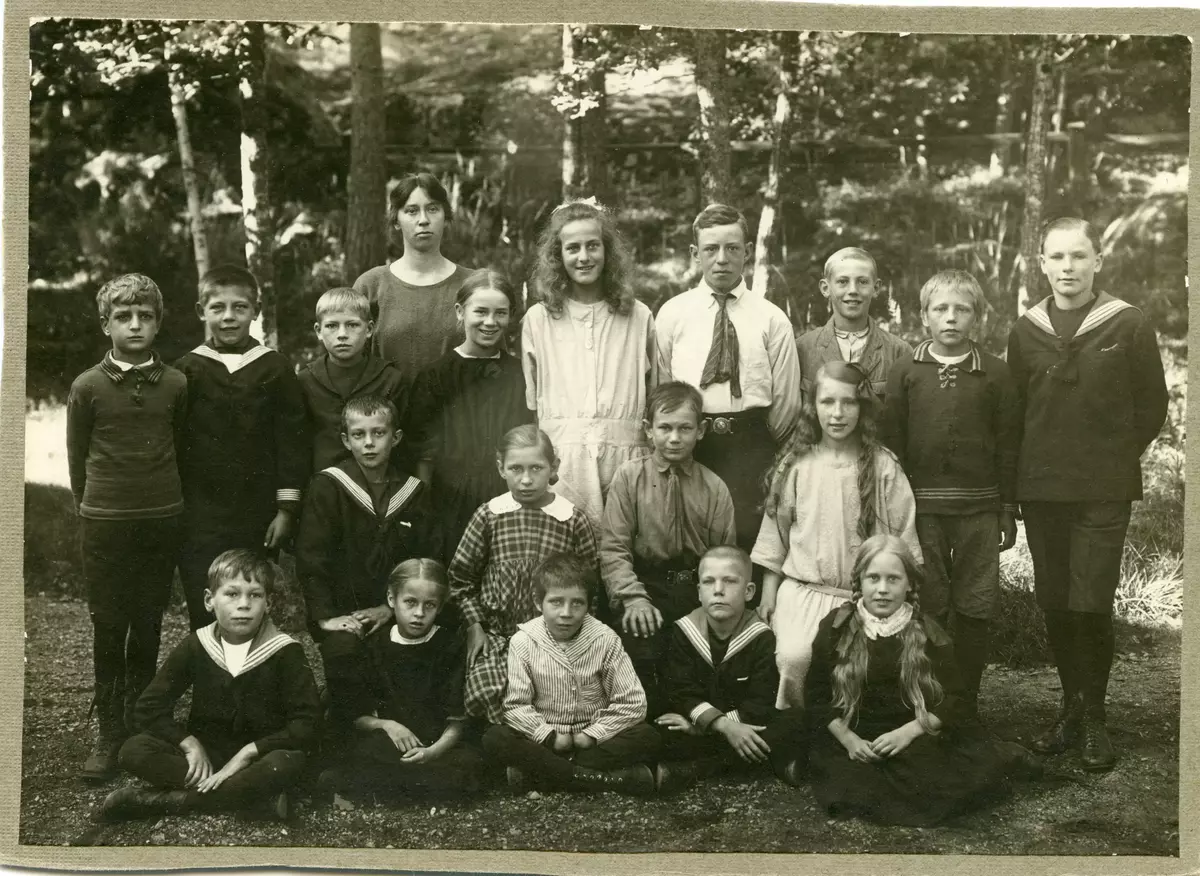 Skolfoto inför skolavslutning en vår något av åren 1923 - 1927. Ett av barnen är Lennart Karlsson, son till Ernfrid och Emma Karlsson, då boende på Strömma gård, i ett hus som sedermera brann ner efter att Lennart slarvat vid passning av eldstaden. Hans syskon hette Linnéa, Iris, Sixten och Greta, någon av dem troligen också med på bilden. Lärarinna var Elsa Maria Lund. På de två andra bilderna ses Lennarts avgångsbetyg från Breviks skola den 1 juni 1927.