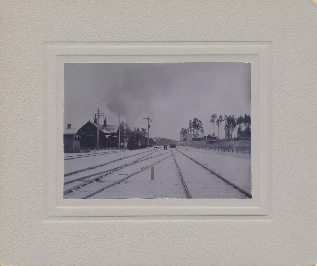 Nykvarns järnvägsstation i vinterskrud kring sekelskiftet 1900. Tåg på väg mot Eskilstuna