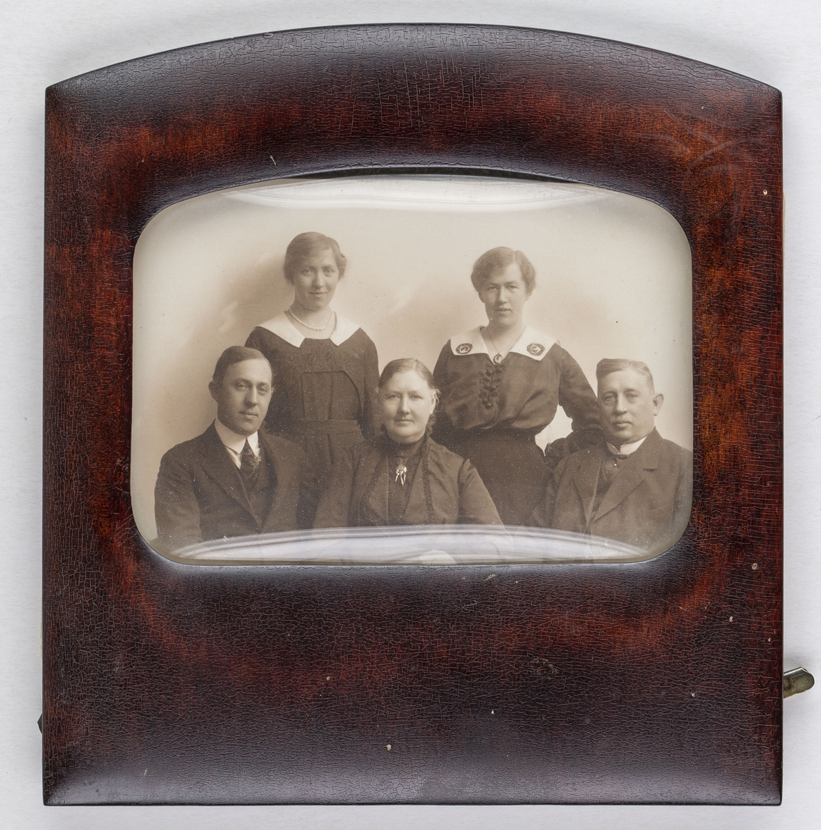 Gruppfotografi i kvadratisk träram med svängd ovansida.
Fotografiet avbildar famlijen Nilson med modern Hanna sittande i mitten, flankerad av till höger fadern Sigfrid och till vänster en av bröderna. Bakom dessa står de två systrarna, Stina till vänster och Carin till höger. 
Ramens öppning är rektangulär med rundade hörn och något svängd uppåt. Glaset som skyddar fotografiet är välvt med den konvexa sidan utåt. 
Fotografiet har en påskrift som går att tyda till Tesch efterträdare, troligen är porträttet taget i Maria Teschs fotoatelier av hennes efterträdare Anna Göransson.
Pappret mellan fotografiet och ramens bakstycke är mönstrat i grönt, gult och svart. Själva bakstycket är reliefpressat och ormskinnsmönstrat och konstruktionen hålls ihop av två klamrar i metall.

Fotografiet finns i Carin Nilsons hem, Villa Lugnet, i Gamla Linköping.