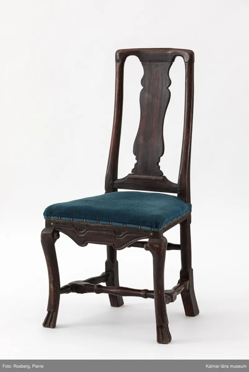 KLM 17713:1-6. Stol, ryggbrickstol. 6 stycken. Av trä och textil. Målad i mörk valnötsimitation. Balusterformad svängd ryggbricka och parallella svängda ryggstolpar. Pilbågsformad framsarg. Svängda framben med tassar till fot. Svarvad tvärslå och sidoslåar, högre svarvad bakslå. Fyra av stolarna har stoppad, läderklädd sits. Två av stolarna har stoppad sits, omklädd i blågrönt tyg. Senbarock.