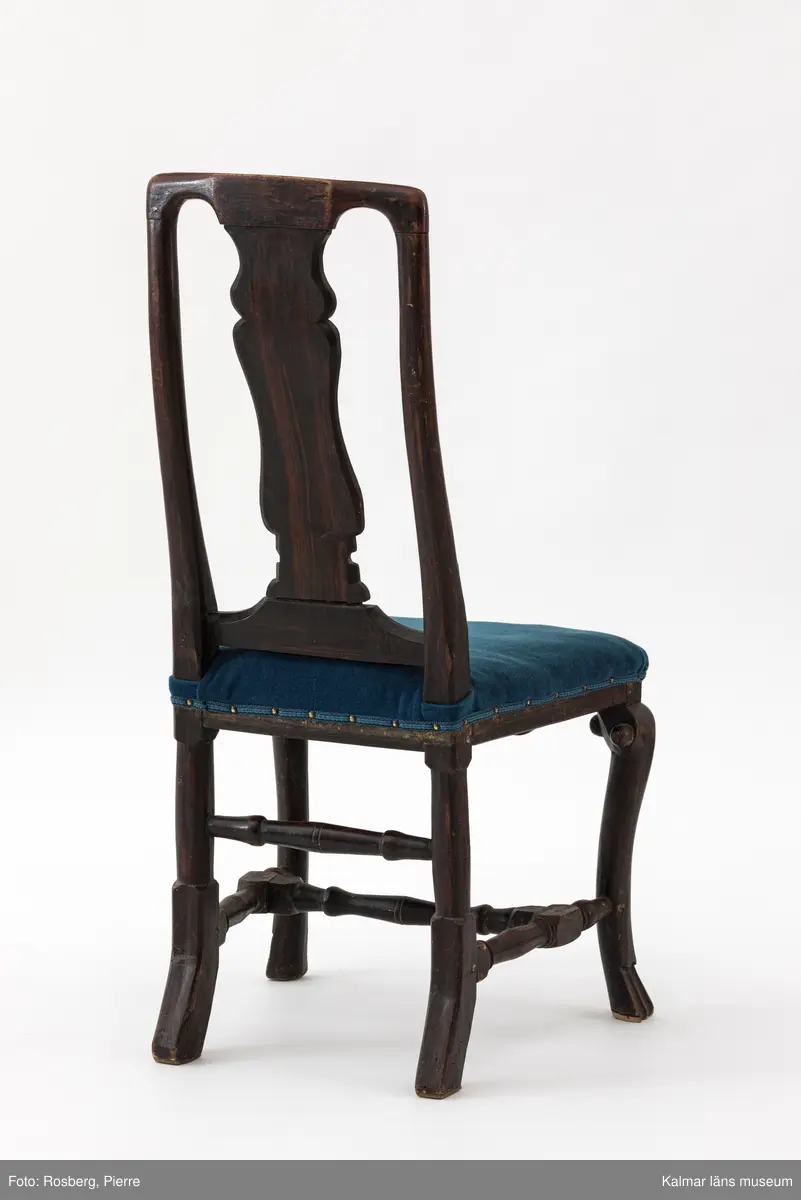 KLM 17713:1-6. Stol, ryggbrickstol. 6 stycken. Av trä och textil. Målad i mörk valnötsimitation. Balusterformad svängd ryggbricka och parallella svängda ryggstolpar. Pilbågsformad framsarg. Svängda framben med tassar till fot. Svarvad tvärslå och sidoslåar, högre svarvad bakslå. Fyra av stolarna har stoppad, läderklädd sits. Två av stolarna har stoppad sits, omklädd i blågrönt tyg. Senbarock.