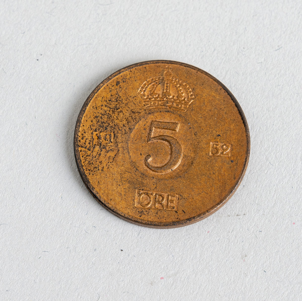 En svensk 5-øre fra 1952. Mynten er laget av bronse. På den ene siden er det valør og årstall, se "Påført tekst/merker". På den andre siden er det tekst med kongens navn. På begge sider er det svenske riksregaliet. Mynten var en standard sirkulasjonsmynt i perioden 1950-1973.