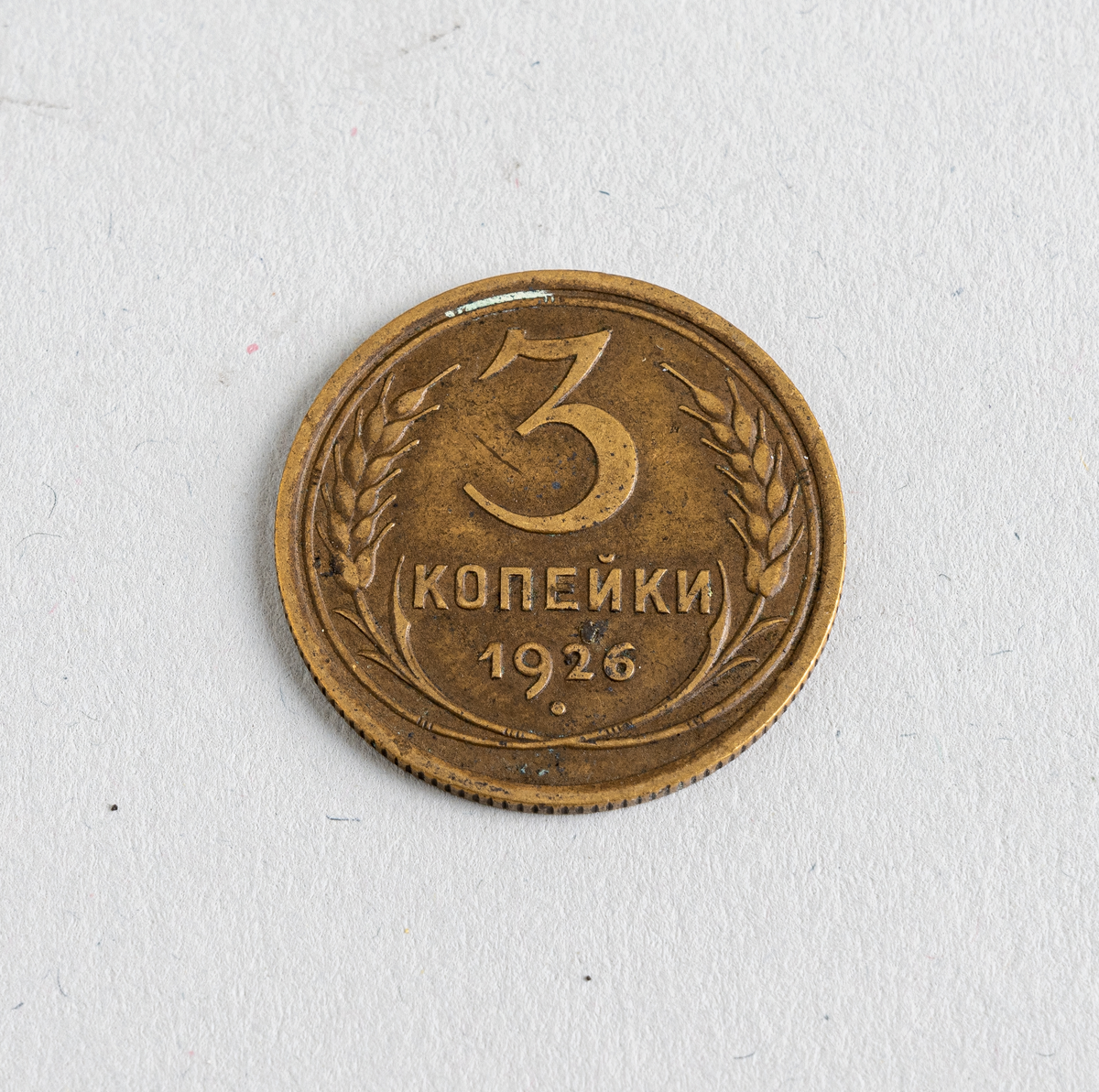 En sovjetisk 3-kopek fra 1926. Mynten er laget av aluminium og bronse. På den ene siden er det valør På den andre siden er også tekst samt illustrasjon av en laubærkrans med sigd og hammer i midten. All tekst er på sovjetisk/russisk. Mynten var en standard sirkulasjonsmynt i perioden 1924-1958.