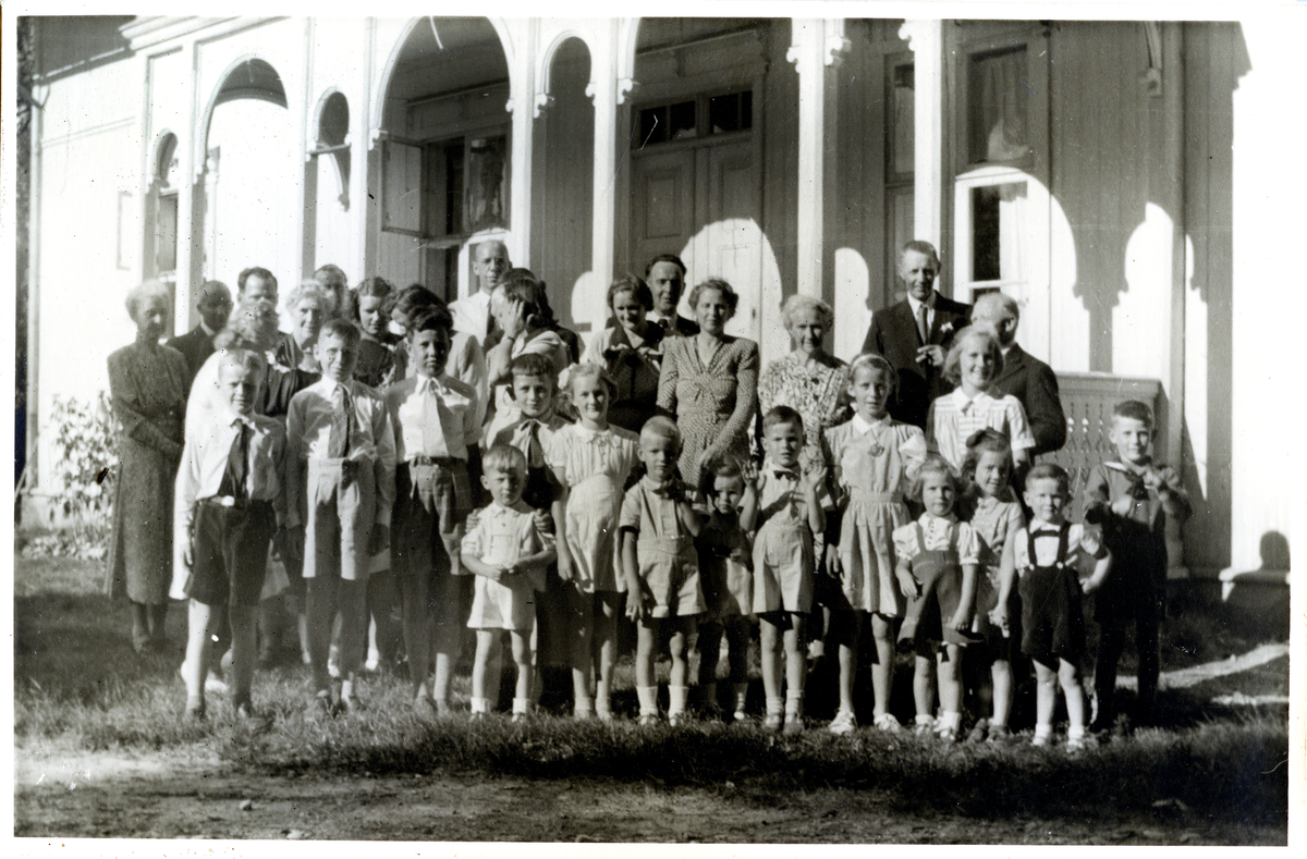 Karen Skavhaugens hundreårsdag 21. juli 1947.
Familiefest på Skavhaugen.
Menn, kvinner og barn.
Bilde er fra fotoalbum GM.036888.