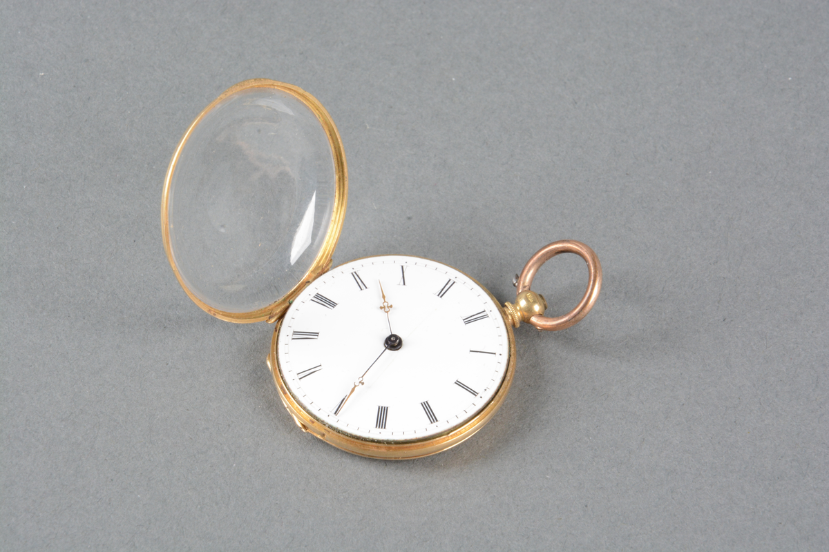 Dobbeltkapslet gull-ur. Hvit emaljeskive med sorte romertall, og spinkle gullvisere med liten dekordetalj på. Urets bakside er guillochert rundt et skjoldformet felt for initial (tomt). 
Det er ikke noe merke på skiven, men innerkapselen er merket med diverse skrifttyper: "ECHAPPEMENT A CYLINDRE trous en pierre" og i lokket 18K 20197
Merket i lokket: Theodor Olsen's Eftf. Juveler  Smaastrandgaten 4 Bergen.