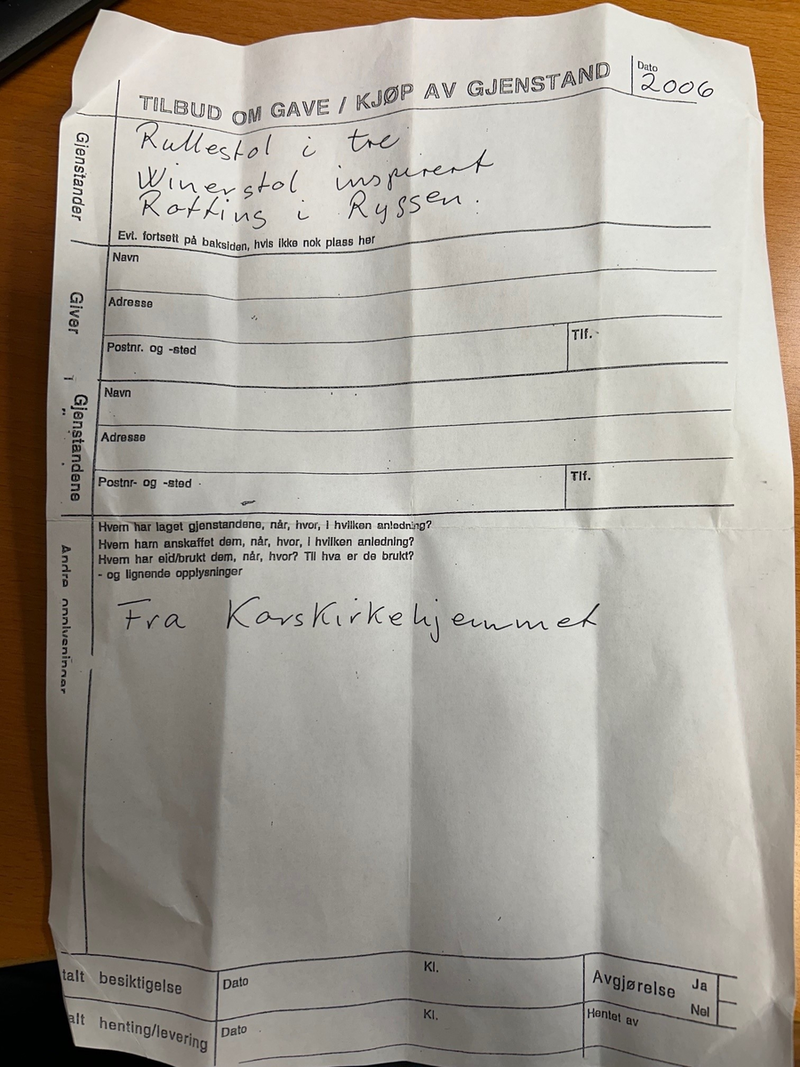 Rullestol i formpresset tre. Fotplate. Håndtak i forlengelsen av ryggen. Rotting rygg. Finert sete erstatter rotting. 2 hjul.