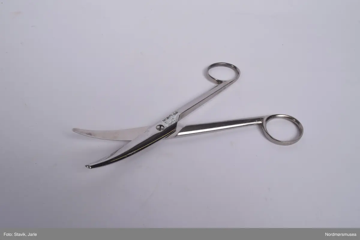 Legeveske i brukt skinn, åpning i toppen. Inneholder de fleste gjenstander man kan få bruk for ved sykebesøk. Dobbelt håndtak, lomme på utsiden kan lukkes med rein. Inni er hovedrom i bunnen med plastlommer med strikk øverst på en siden. Under denne to plastlommer med klaff. Et mindre skille av bunnen med skillevegg av gjenomsiktig plast. Inneholder numrene SU.3018a-3018s.
a) Etui for urinkatetere med fire katetre. Sylinder av gjennomsiktig plast med rød gummitopp i hver ende. 39 cm lang, 4 cm bred.
b) Sylindrisk metalletui i to deler for "smøreolje". Riller på siden fungerer som gjenger og dekorasjon. 78 cm langt, 4 cm diameter.
c) Todelt sylindrisk pappetui med reagensrør inni. 16,2 lang, røret 15,5 cm langt.
d) Termometer fra Villiers, merket ATOMIC. Liten glasshempe i toppen. 17 cm langt.
e) Tomt etui i messing med røde plastender. Irret.
f) Tomt etui i brunt skinn for blodtrykksapparat. Glidelås langs begges sider og topp. 17x12 cm.
g) Etui i eggehvit plast. Todelt med hengsling, inneholder staseslange produsert av Premeta Stauer. Brukes ved blodprøvetagning for å stramme rundt armen for å få fram blodårene.
m) Saks med krumme blader. 13 cm lang.
n) Skaplell med utfellbart blad. En skyvelås brukes for å hindre bladet i å folde seg sammen. Produsert av A. Rudds eftf. 14,5 cm lang utslått.
o) Anatomisk pinsett prdusert av Stille - Sverige. 13 cm langt.
p) To artieriepinsetter. Sakslignende pinsetter for å klipe igjen blodårer.
r) 4 pakker med steril suturtråd prod. av Davis & Beck Division American cyanid company. 1 pakke gasbind 4cmx5cm, 1 pk steril bomullsbandasje prod. av Beng & tegner & Co 25gr, 1 pk steril gasbind 1/4m, 1 stk trekantforkle 2,70.
s) 2 tungespatler i plast, 14,5 cm lang.