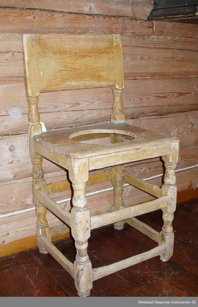 Senrenessanse type stol fra ca. 1700. 8 stk. bindingssprosser holder beina sammen (8 takker stol). Dreide føtter. Sete laget av to bord. Bredt vannrett, toppstykke, tappet inn i dreide akterstaver. Rester av blågrå og gul/oker lignende farge. Omgjort til dostol (nyere dato).