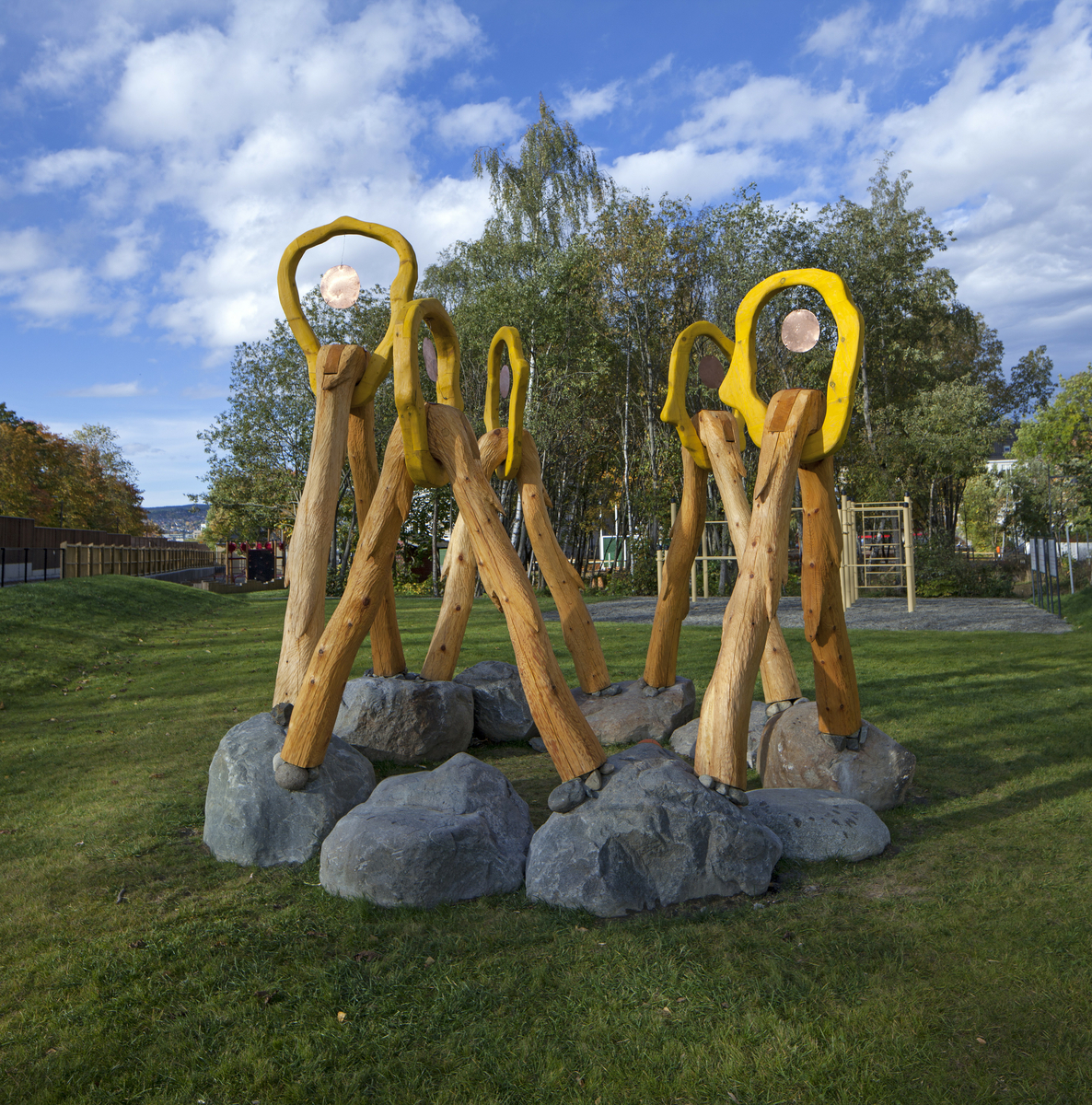 Skulpturen hentyder til formen av blomster/hoder og knyttes sammen i en helhetlig skulptur. Skulpturen vil springe ut av store naturstein som plasseres i ringformasjon, hvor 2 “blomsterstilker” er knyttet til hver stein, og hvor to stilker fra to ulike steiner møtes i et blomsterhode. Formen er inspirert av hestehoven, en blomst som mange forbinder med lysere tider og vårens anmars. 

Lysskulpturene består av uthulet trestammer. 