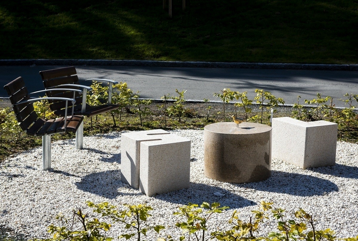 I uteområdet blander skulpturer av den danske billedhuggeren Jørn Rønnau seg med trær, busker og blomster i to separate hagerom. Det ene har kunstneren kalt «Torvet» og satt inn en hel gruppe skulpturer. Blader fra ulike treslag, bjørk, eik, bøk, ask og pil har gitt formmessig inspirasjon til fem sitteskulpturer i polert granitt. På de glatte sitteflatene har Rønnau plassert små bronsefigurer av ekorn, frosk og mus. De bladformete «benkene» er gruppert rundt en sentral bronseskulptur, et rødt kjærlighetens hjerte. Store runde bed for blomster og busker hører også med til kunstnerens prosjekt.

Det andre hagerommet har en oval form og har fått navnet «Den grønne øya». Her lar Rønnau de samme treslag gro opp, bjørk, eik, bøk, ask og pil, som sammen danner en svungen allé diagonalt over «øya» og deler den i to. På hver side av alleen danner en sirkelrund hekk en intim sitteplass. Den ene har en gulskimrende granittskulptur i tre deler, som sammen danner ordet «sol» og hver for seg fungerer som stoler og bord. På bordet har for øvrig en bronsefugl slått seg ned. Mens denne siden har dagen som tema, preger natten den andre. Her har Rønnau satt inn en granittskulptur formet som en stjerne. Ovenfra kan Den grønne øya ses som yin og yang, det eldgamle orientalske symbolet for de motstridende, men utfyllende krefter i verden.