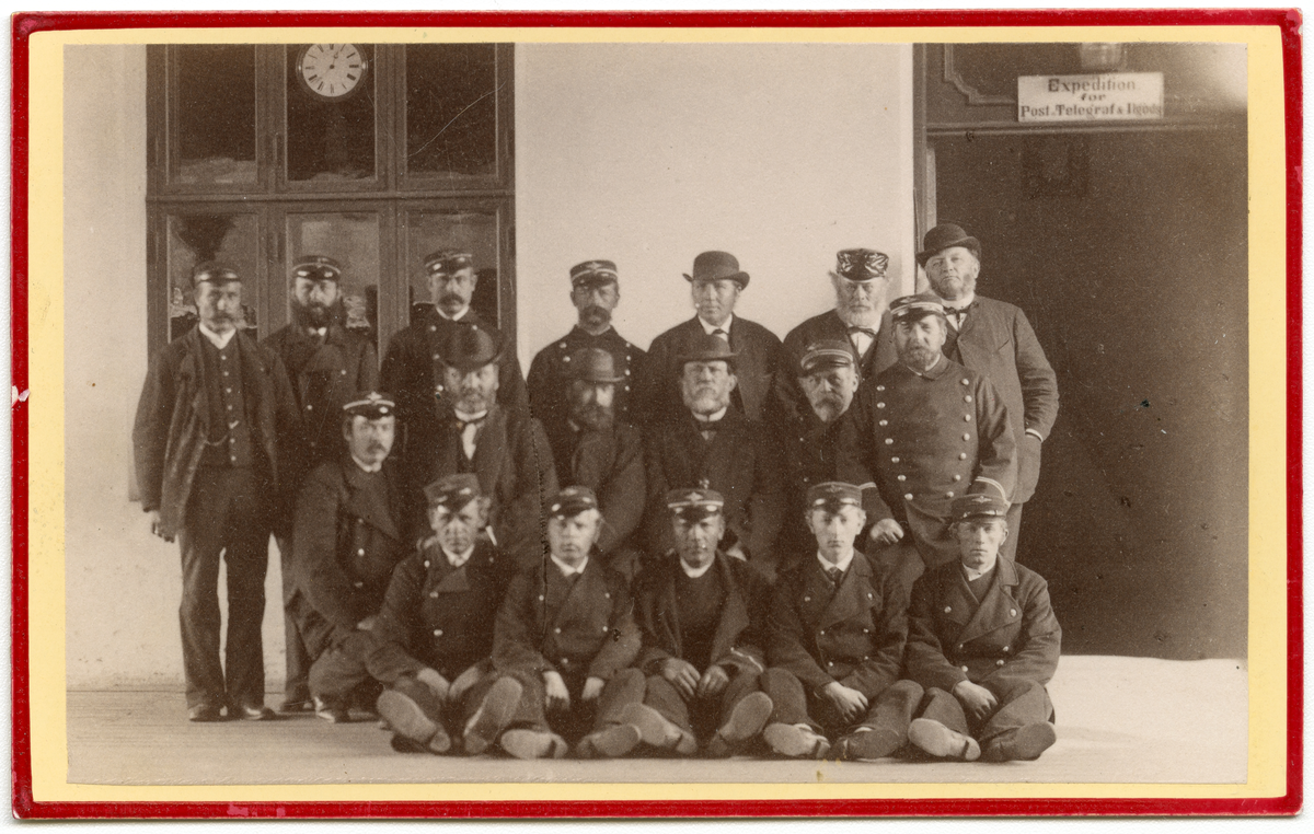 Foto av menn i uniform utenfor expedition for Post og Telegraf. Mulig ansatte på hovedjernbanen. 

I bakerste rad helt til høyre kan man se ingeniør ved hovedbanen Christian Theiste (1830 - 1898). I andre rad som nr. 2 fra venstre sitter overbanemester ved hovedbanen, Johan Hønen (1829 -)