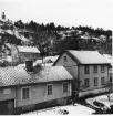 Utsikt från fönster mot bebyggelse utmed Brahegatan i Gränna. Det ligger ett tunt snötäcke på hustak och mark.