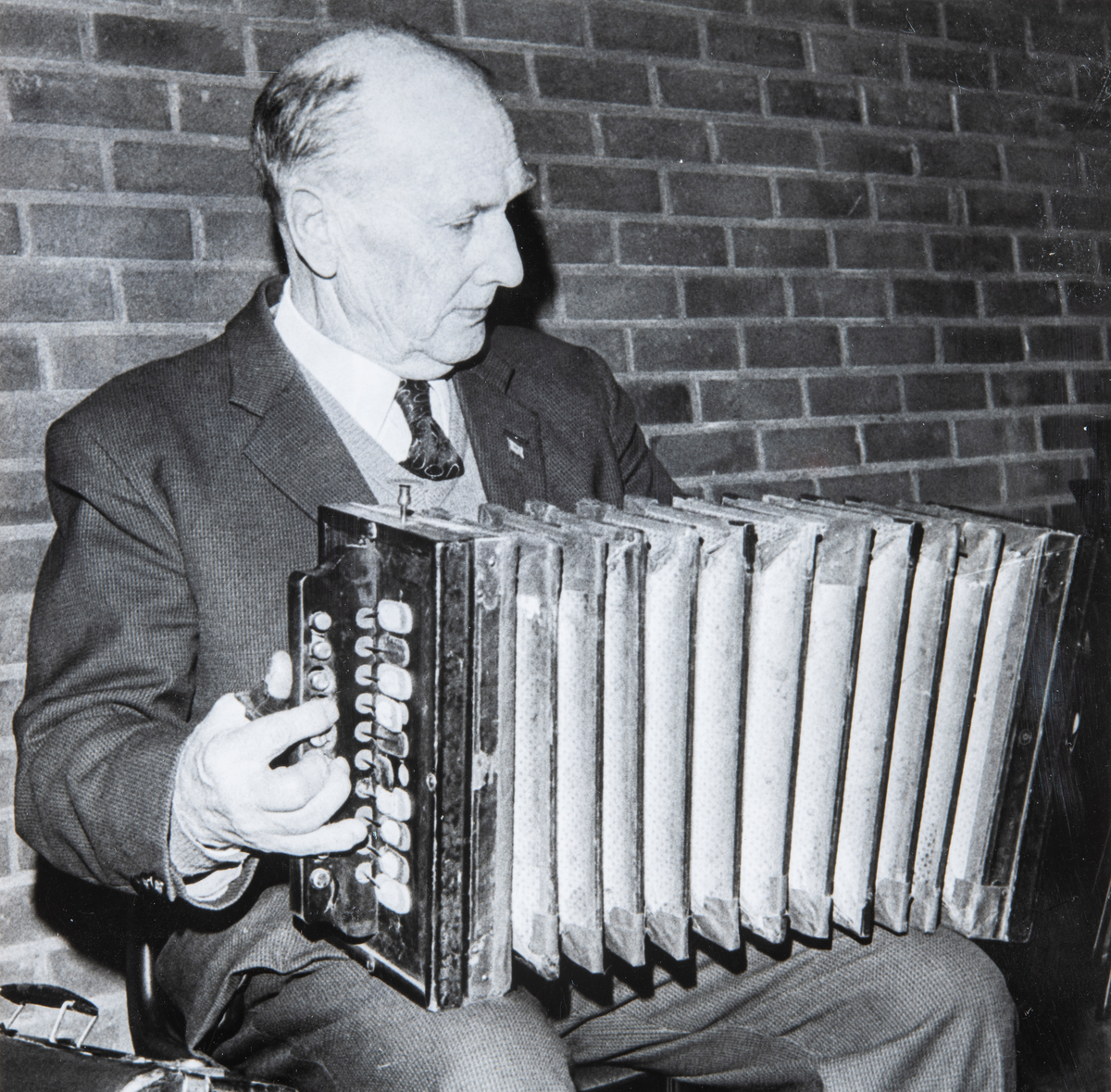 Otto Jensen underholder med trekkspill musikk på et møte i Ottestad Pensjonistforening. Otto gikk også under kallenavnet "Fjetrebakken"