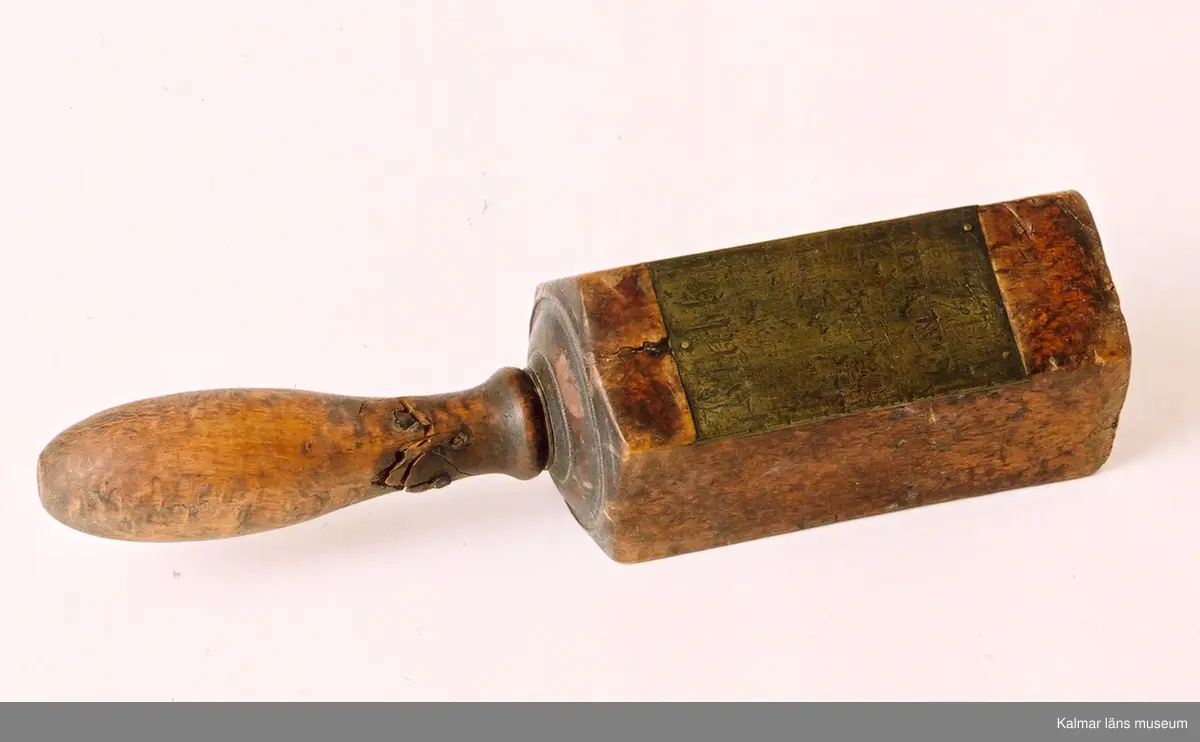 KLM 21316. Klubba, patrouilleringsklubba. Tillverkad av trä, masurbjörk och mässingsplåt. Femkantig klubba med på ena sidan graverad mässingsplåt med text: Klubba för Patrouilleringstouren i Calmar börjad d 1 Decemb 1828. Skaftet sönder, äldre lagning med järnnit.