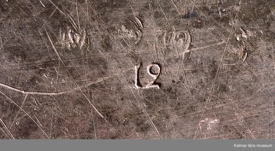 KLM 24063. Fat. Av tenn, hamrat. Stämplar på undersidan: 1 st kontrollstämpel, två stadsstämplar för Västerås mycket otydliga. l 2= 1793. Två mästarstämplar för Hans Wiksten, otydliga. Rosstämpel i oval.