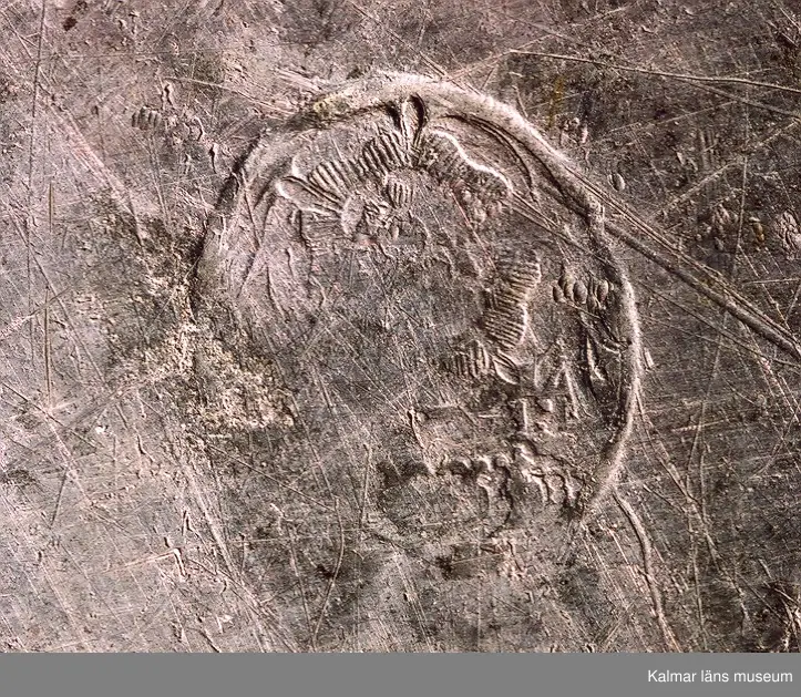 KLM 24063. Fat. Av tenn, hamrat. Stämplar på undersidan: 1 st kontrollstämpel, två stadsstämplar för Västerås mycket otydliga. l 2= 1793. Två mästarstämplar för Hans Wiksten, otydliga. Rosstämpel i oval.