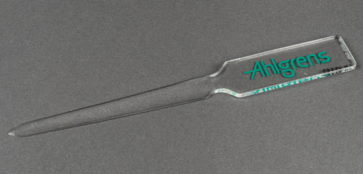Brevkniv i plast, genomskinlig med grön text: Ahlgrens.
