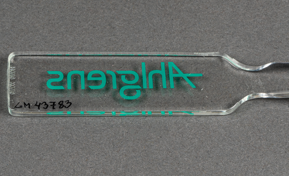 Brevkniv i plast, genomskinlig med grön text: Ahlgrens.
